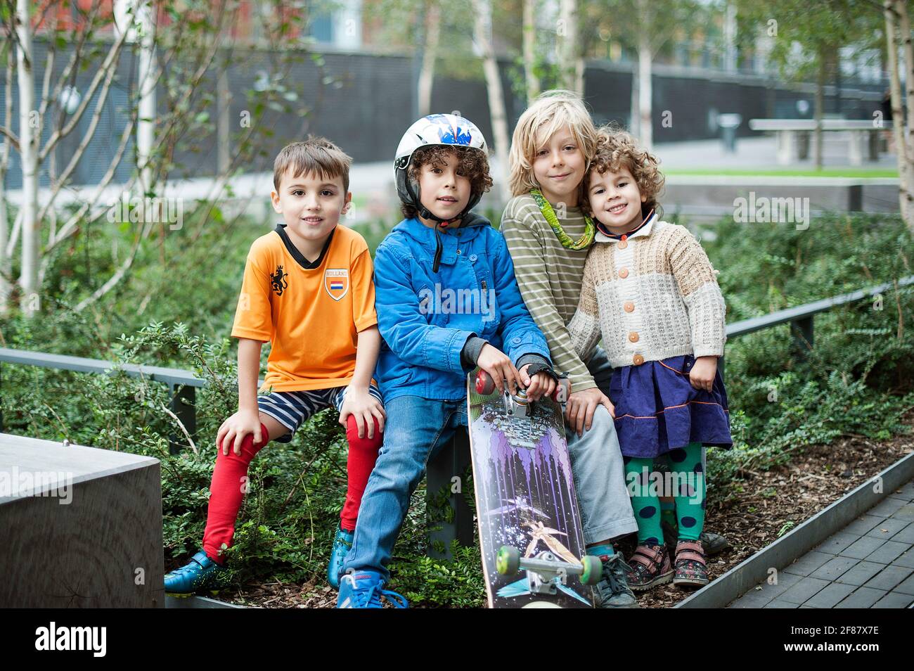 A group of young English children sitting together for a portrait shot. Dalston Square, Dalston E8, London, UK. Editorial use only. Oct 2015 Stock Photo