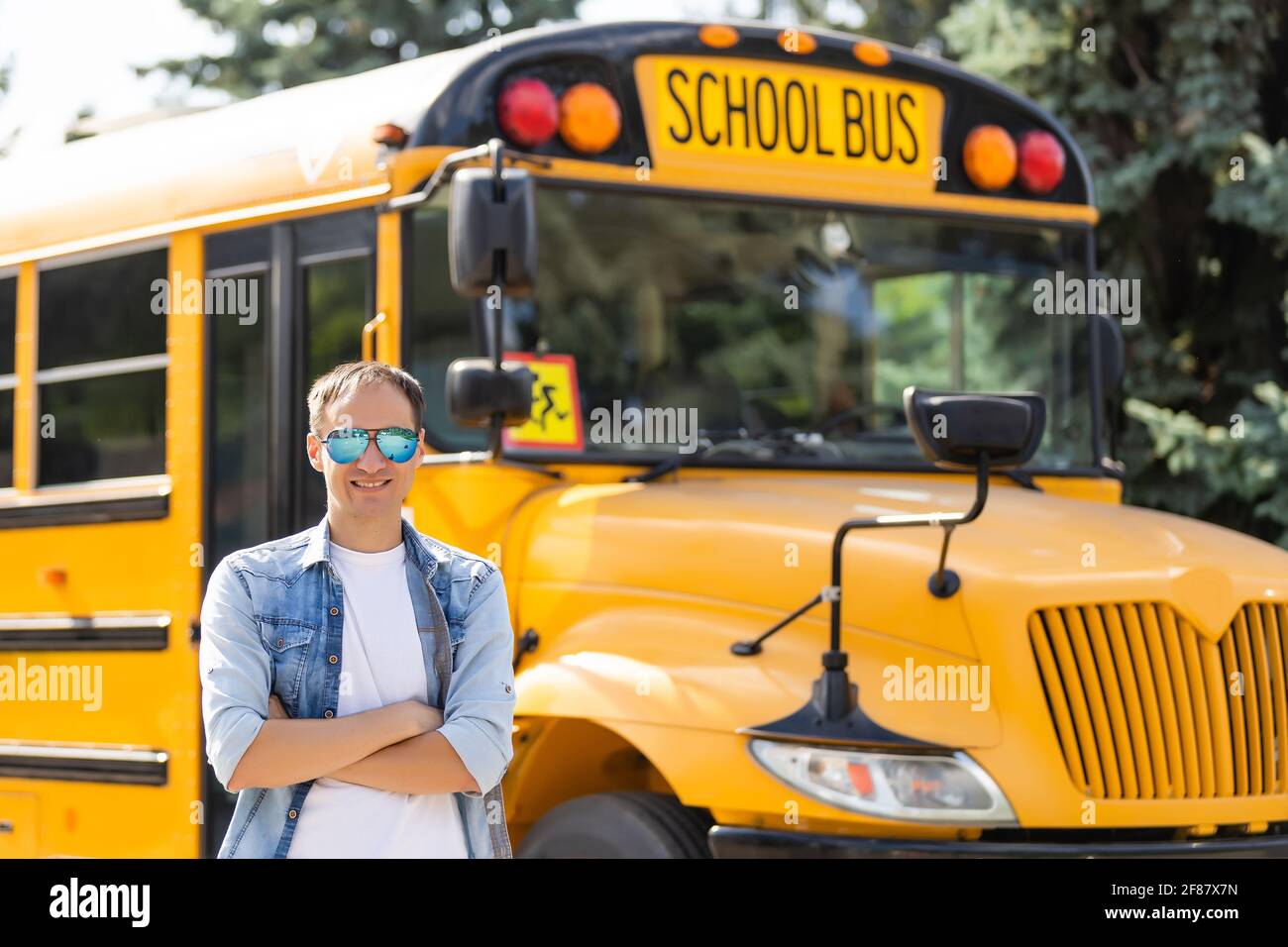 Portrait of smiling teacher near school bus Stock Photo - Alamy