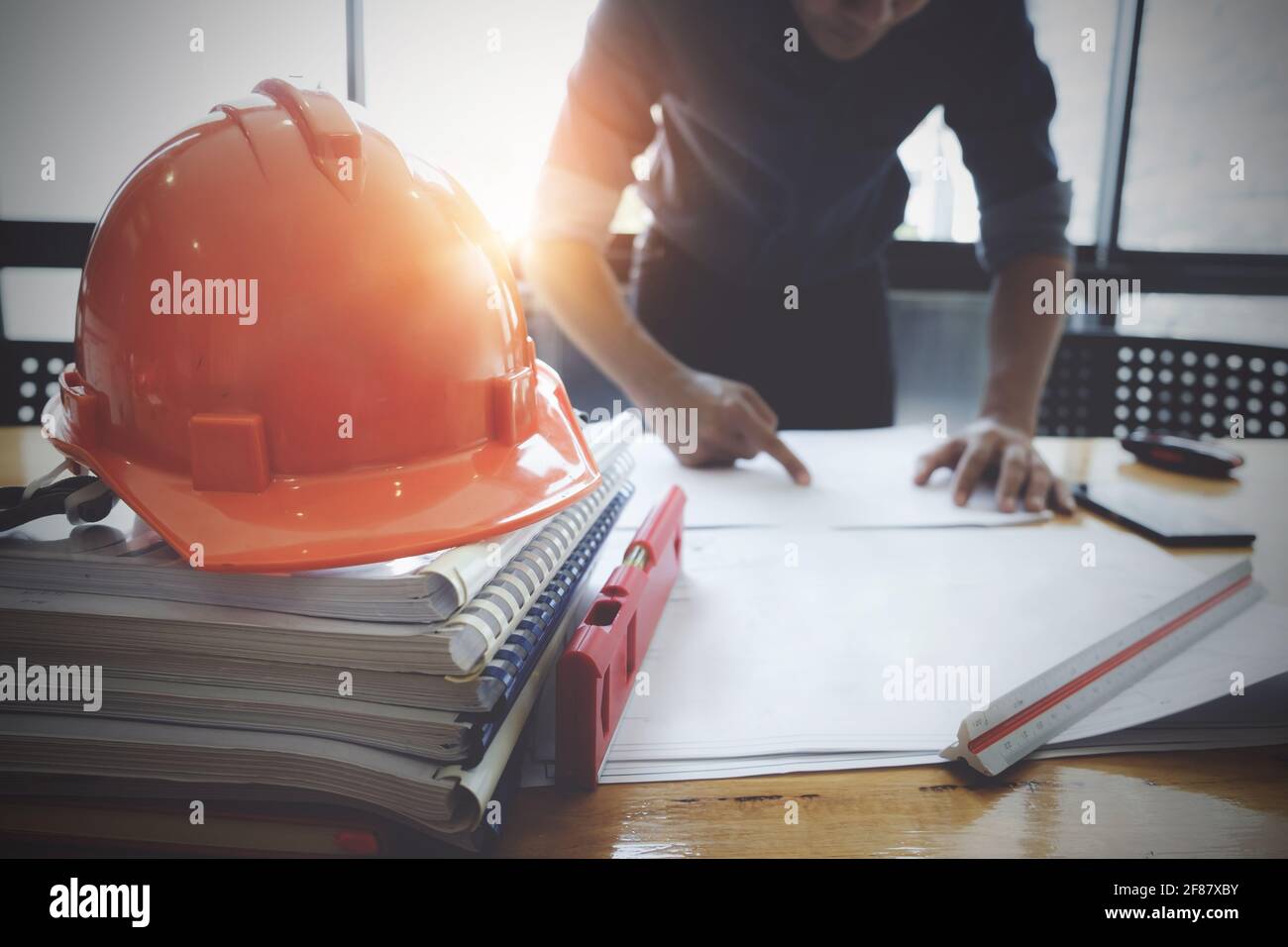 Interior Architect with blueprint for architectural plan, engineer sketching a construction project concept in engineer office. Stock Photo