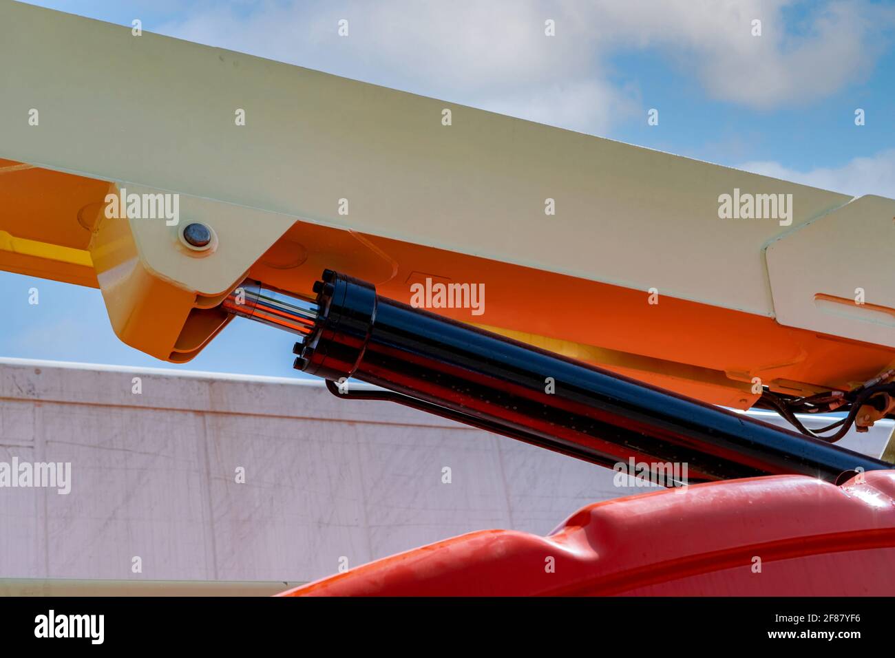 Closeup hydraulic of boom lift. Orange articulated boom lift