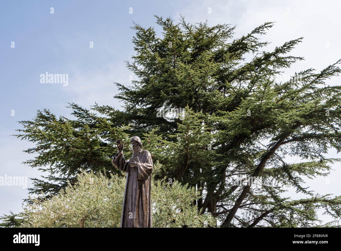 Statue of Saint Charbel in front of a Cedar tree, Monastery of Saint Maroun, Annaya, Lebanon Stock Photo