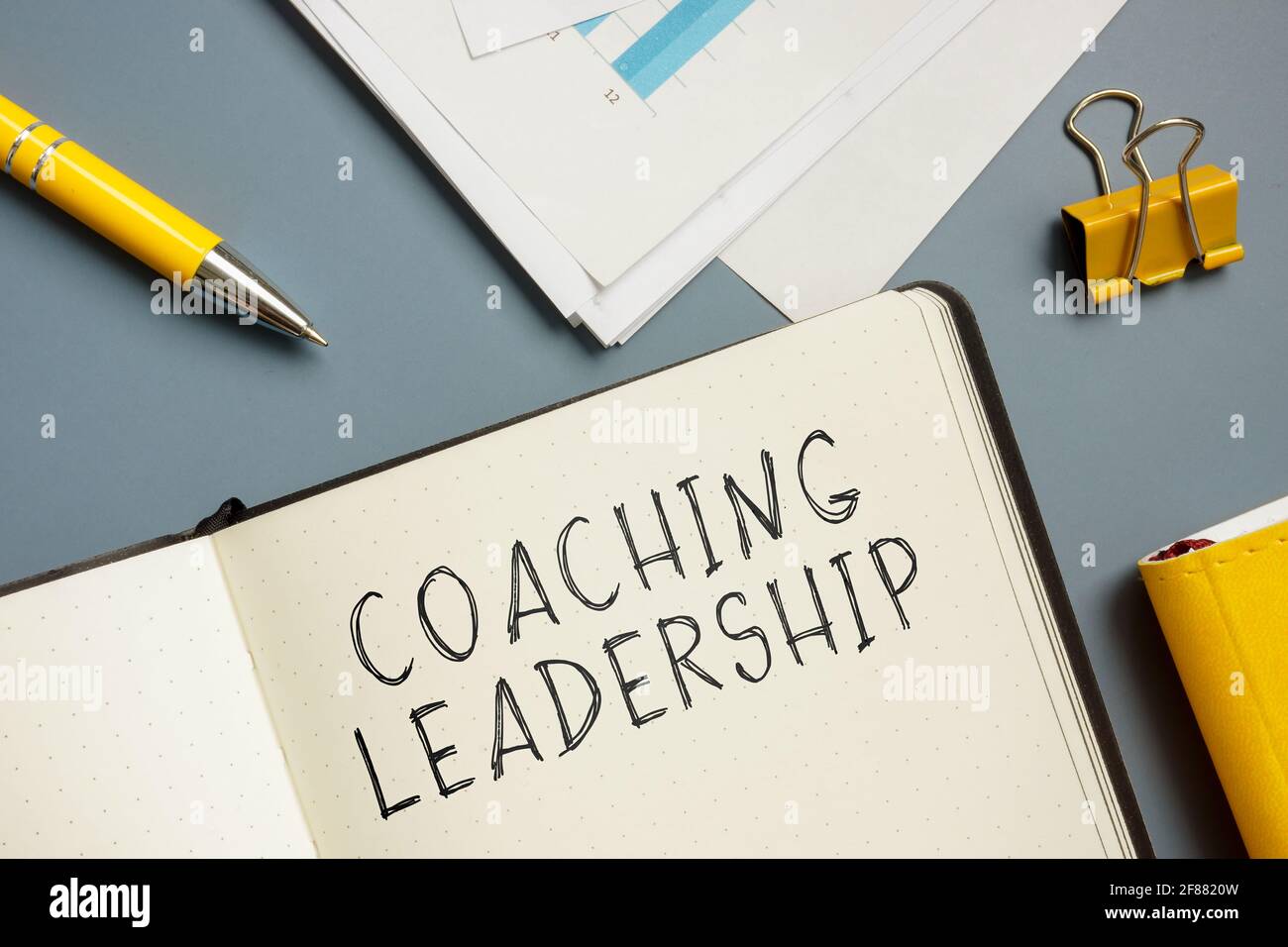 Marks about coaching leadership in the notepad. Stock Photo
