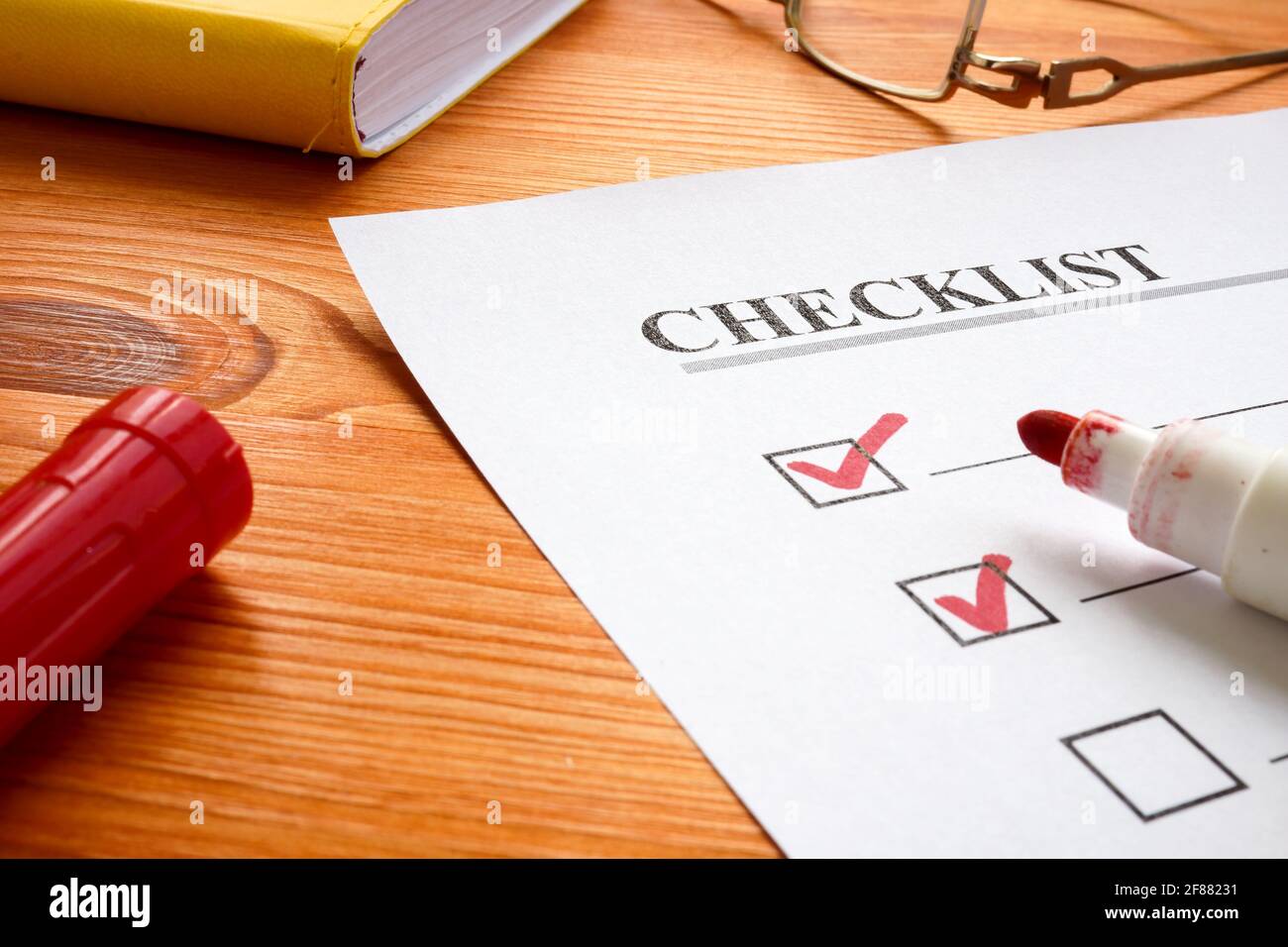 Checklist with marks and red marker on the desk. Stock Photo