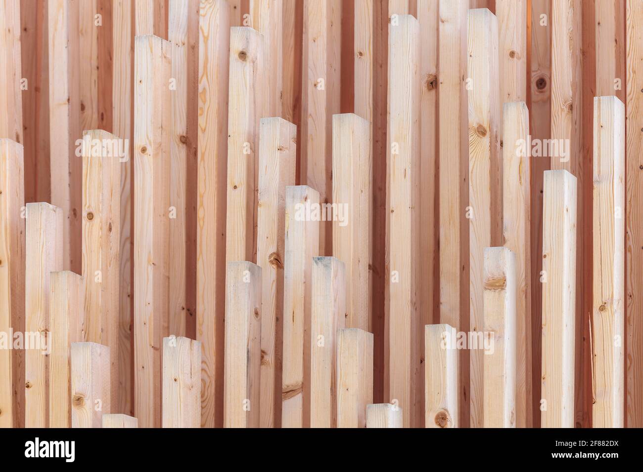 Vertical row of new wooden girders with different lenghts Stock Photo