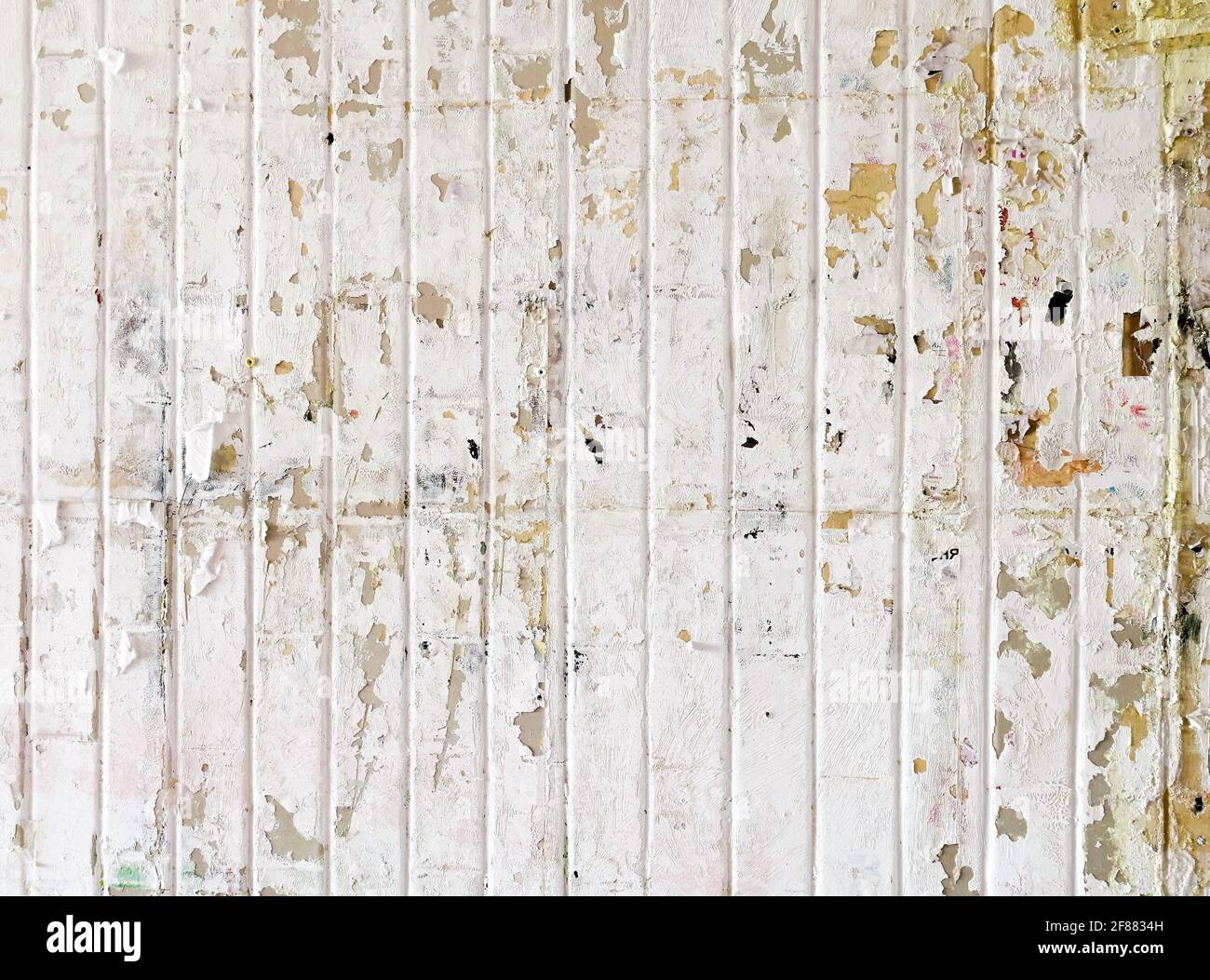 Urban background, white ruined industrial wall with creased crumpled placard. Stock Photo