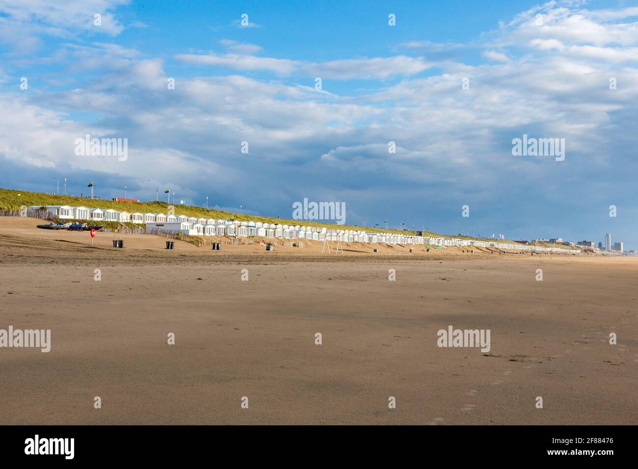 White beachhouses at the deserted and wide beach of Bloemendaal aan Zee, Netherlands. On a cloudy day. Stock Photo