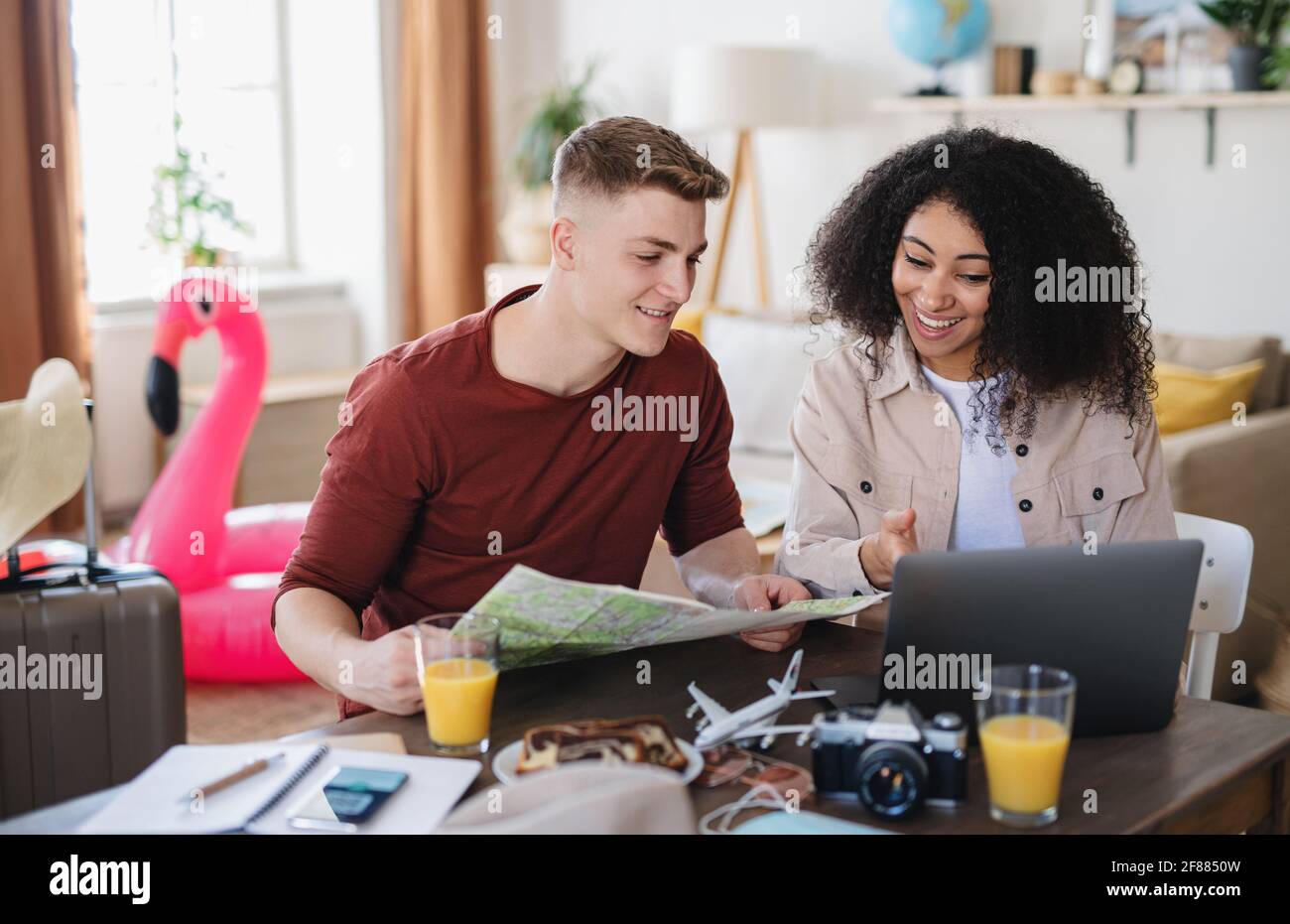 Young couple with laptop packing for holiday, coronavirus concept. Stock Photo
