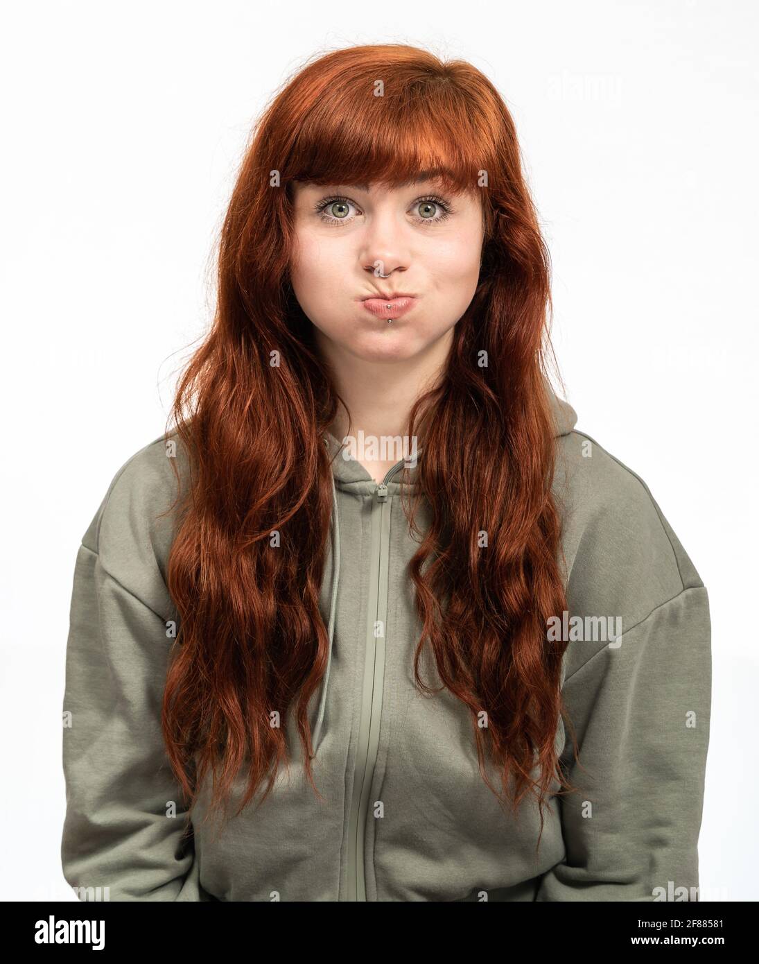 Portrait of a woman with red hair infront of white background having chubby cheeks Stock Photo