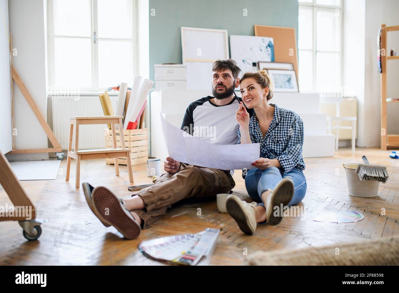 Mid adults couple planning indoors at home, relocation and diy concept. Stock Photo