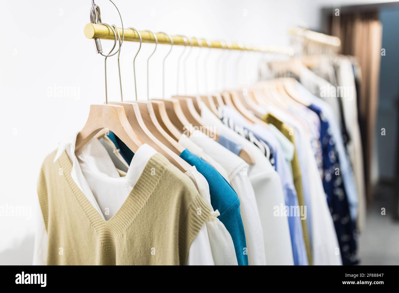 Row of different female clothes hanging on rack in hipster fashion show  room in shopping mall. Trendy women wear Stock Photo - Alamy