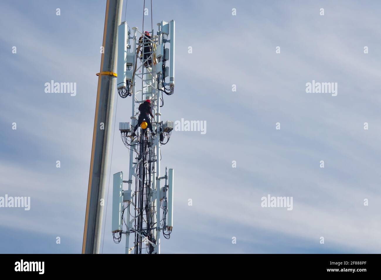 Assembly of a new 5G network telecommunications tower with two technicians in The Netherlands Stock Photo