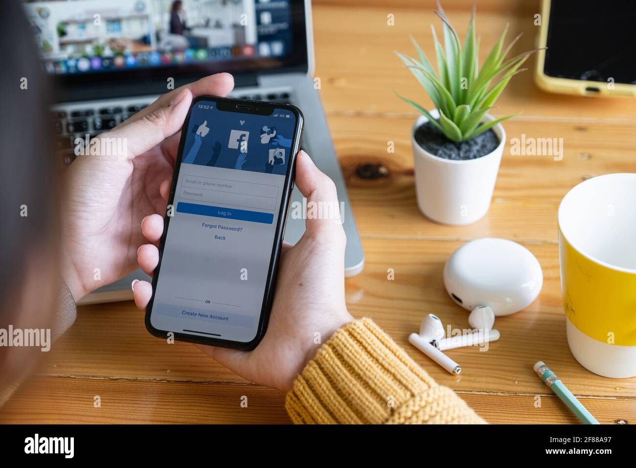 businessman show Facebook login page on his smartphone for using