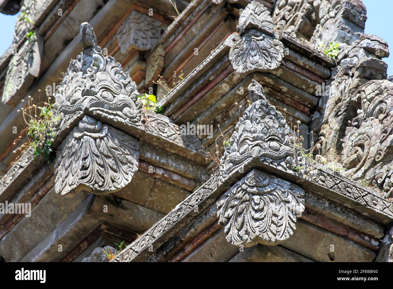 Traditional stone carvings of faces on roof of building in Bali, Indonesia Stock Photo