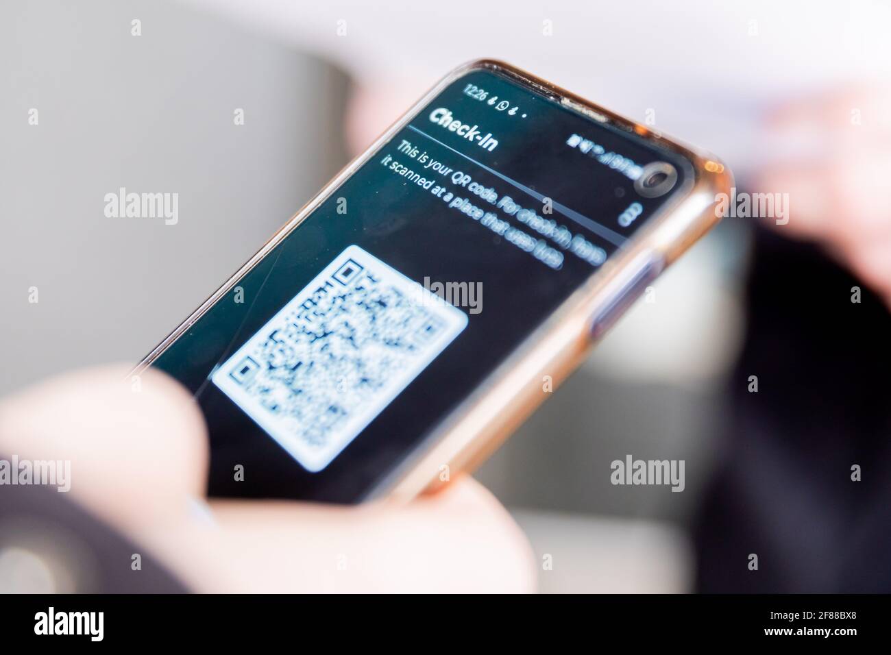 Berlin, Germany. 12th Apr, 2021. 'Check-In' is written in a person's Luca app at the entrance of a clothing store at Alexanderplatz. The app is used to provide data for possible contact tracing. Credit: Christoph Soeder/dpa/Alamy Live News Stock Photo