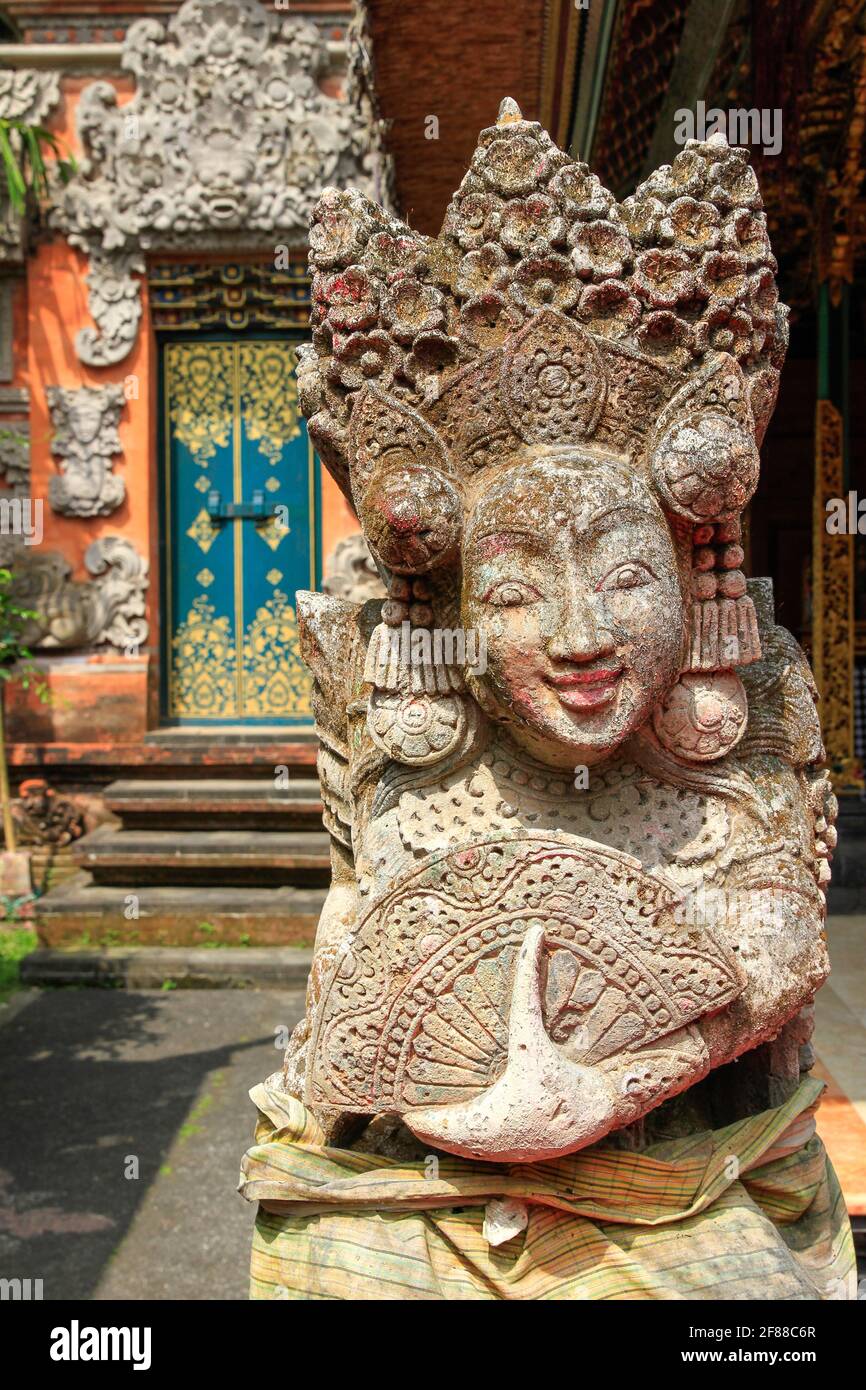 Traditional stone carved statue of woman wearing headless with fan in Bali, Indonesia Stock Photo