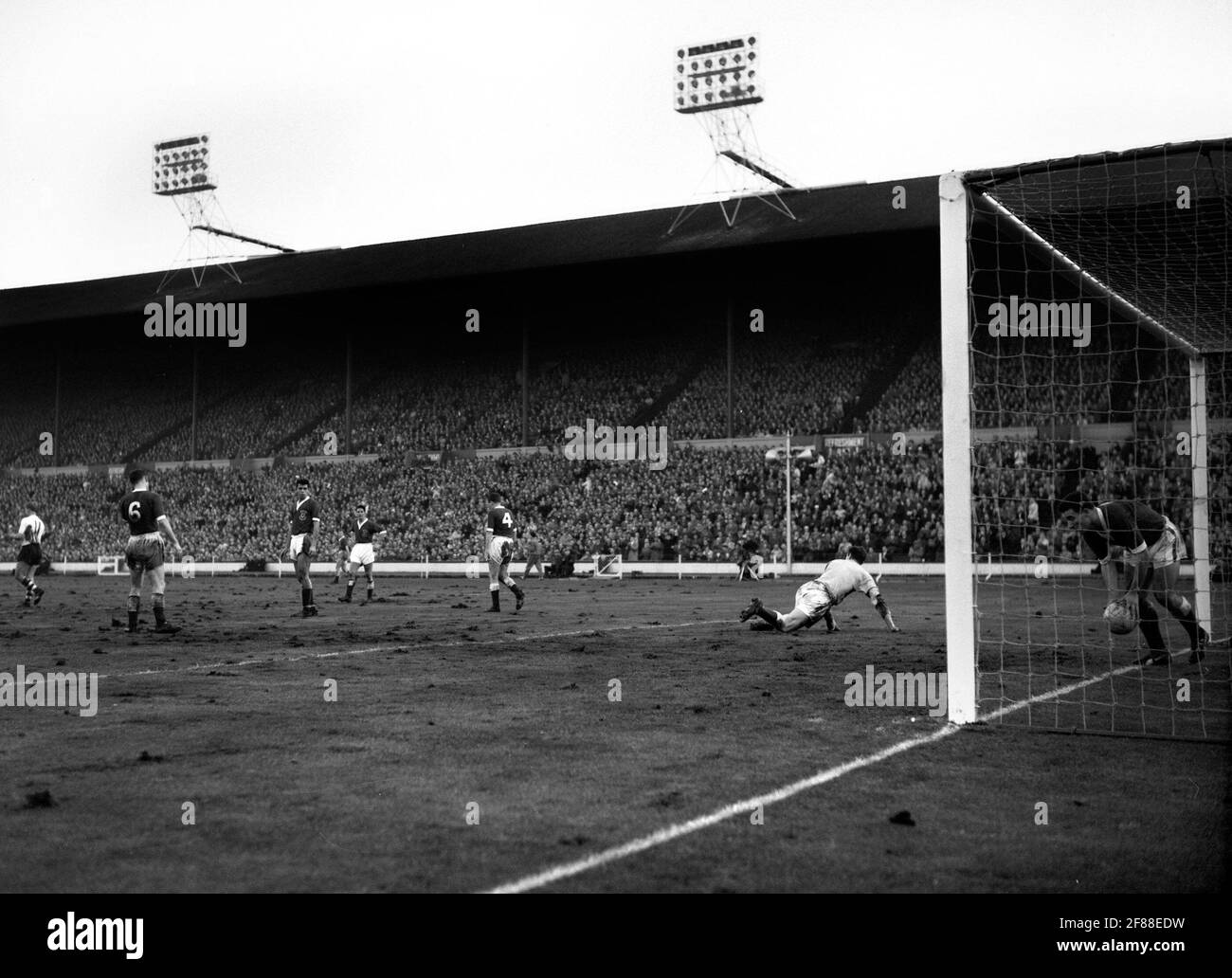 File photo dated 23-11-1960 of Graham Williams (Wales) picking the ball out of the net after Johnny Haynes scored England's fourth goal. Other Welsh players seen L-R are; Colin Baker (no.6), Mel Nurse, Alan Harrington, Vic Crowe (no.4) and goalkeeper Jack Kelsey. England won the match 5-1. Issue date: Monday April 12, 2021. Stock Photo