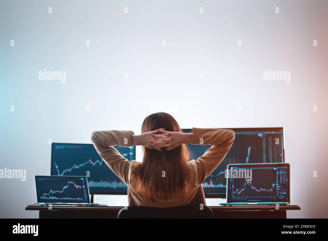 back view of female crypto trader resting and looking at monitor stock  exchange Stock Photo - Alamy