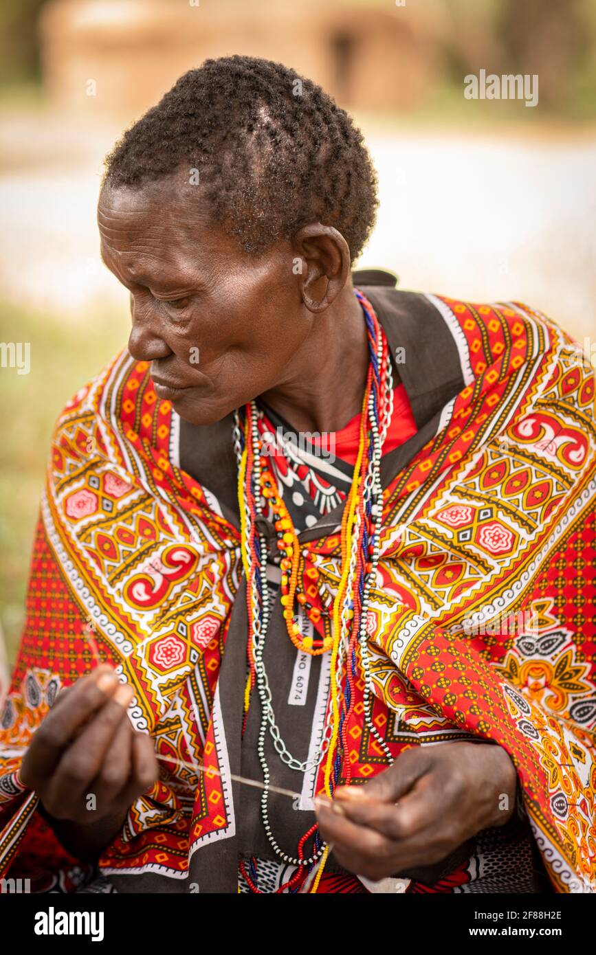Maasai woman with thread to make beaded bracelet Stock Photo