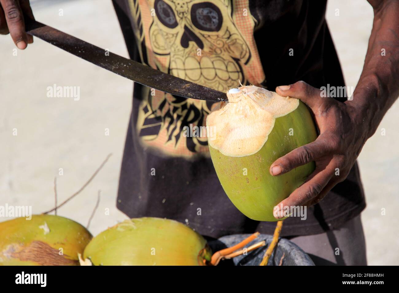 Man opening coconut with Machete, San Pedro, Belize Stock Photo