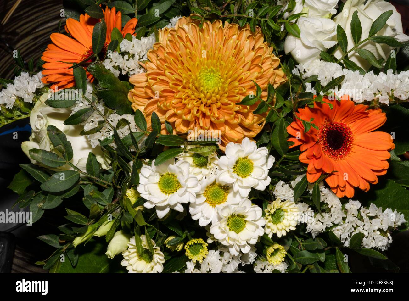 A closeup picture of a bouquet of funeral flowers. White, yellow and