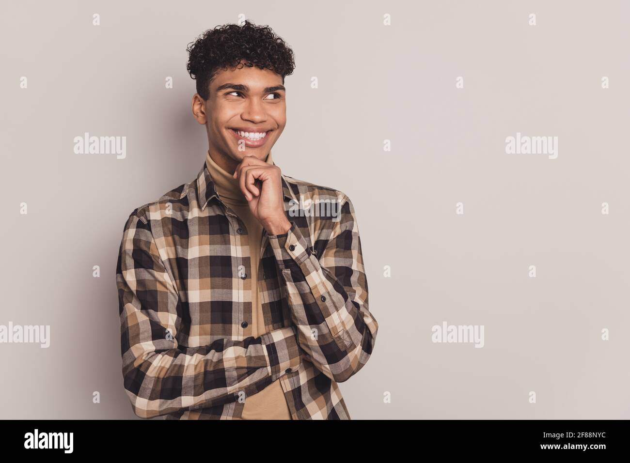 Photo of minded happy dark skin young man look empty space hold hand ...