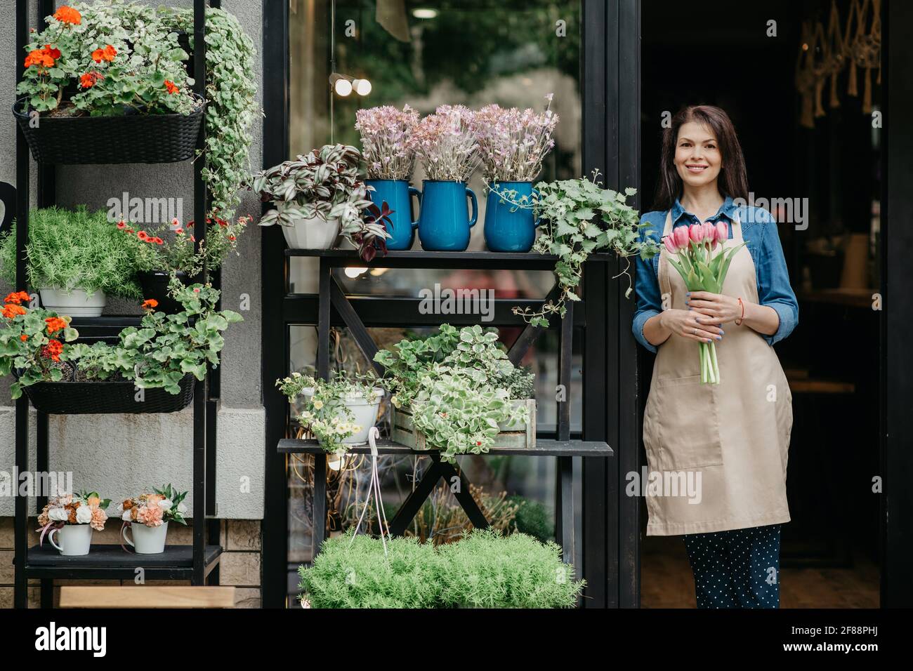 Woman florist reopening shop after covid-19 pandemic, delivery service for clients Stock Photo