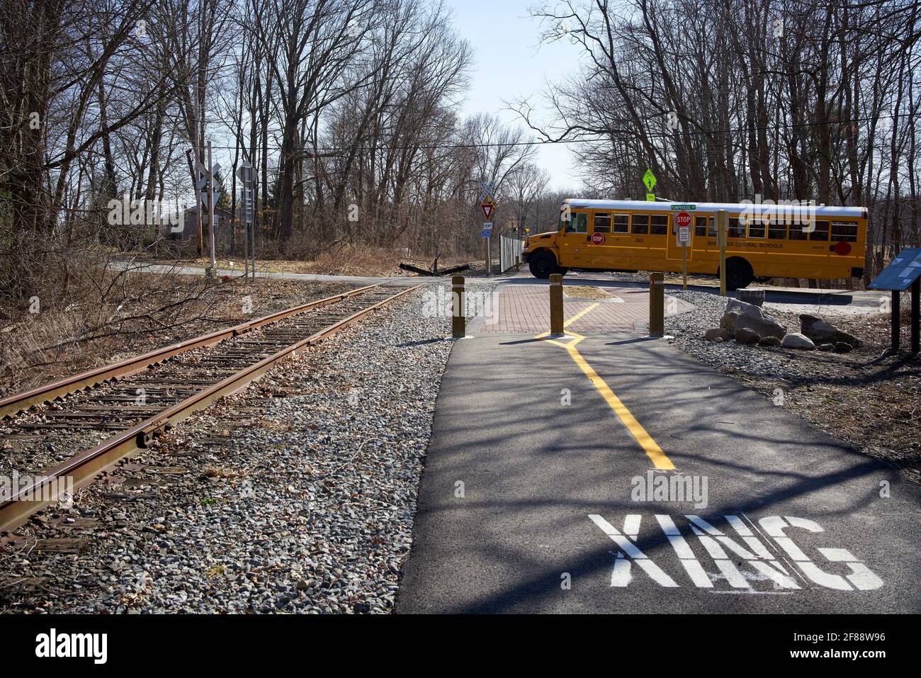 American yellow schoolbus crossing a railroad. Stock Photo