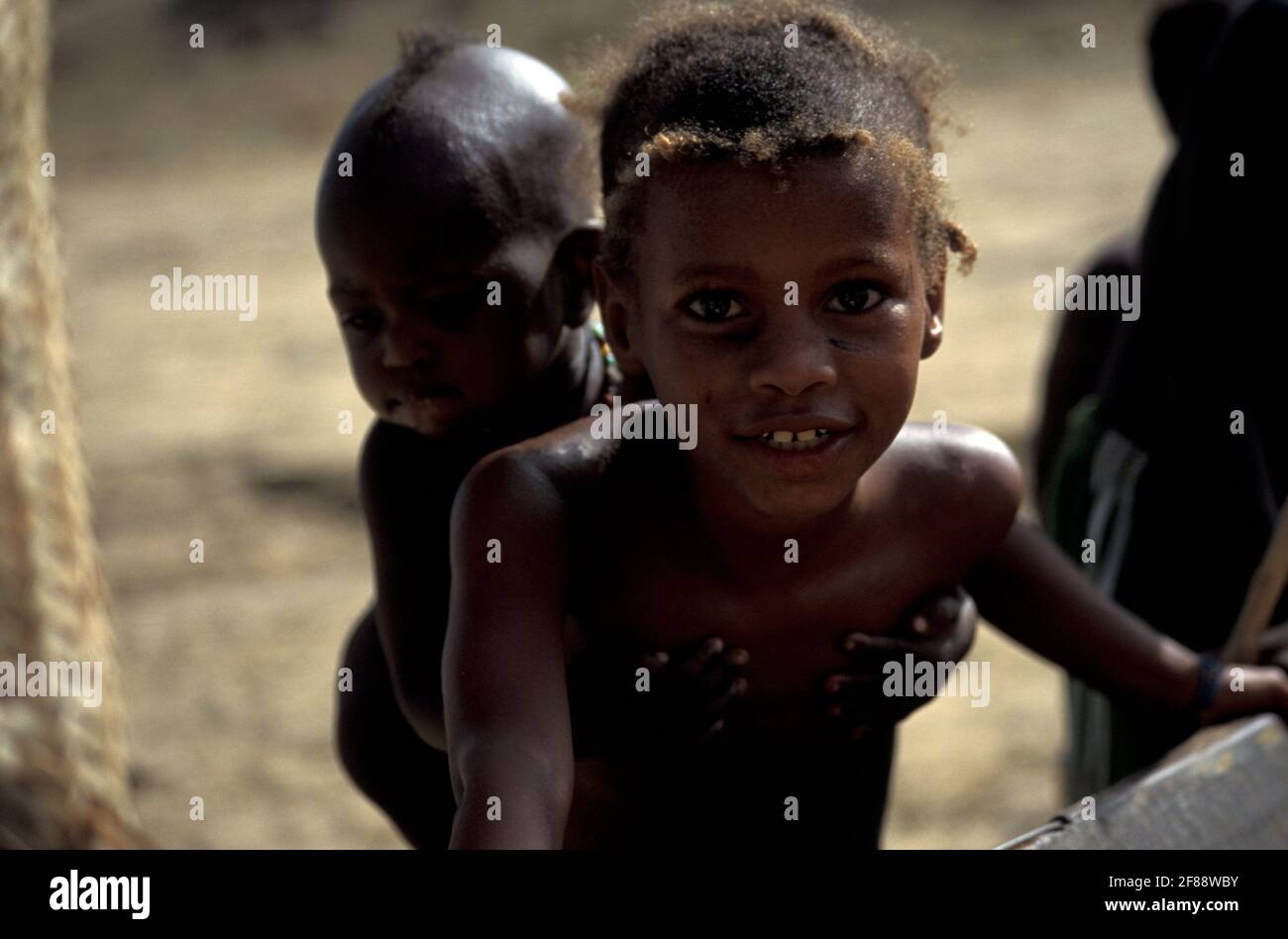 Girl carrying a baby in her back, Mopti, Inner Niger Delta region, Mali Stock Photo