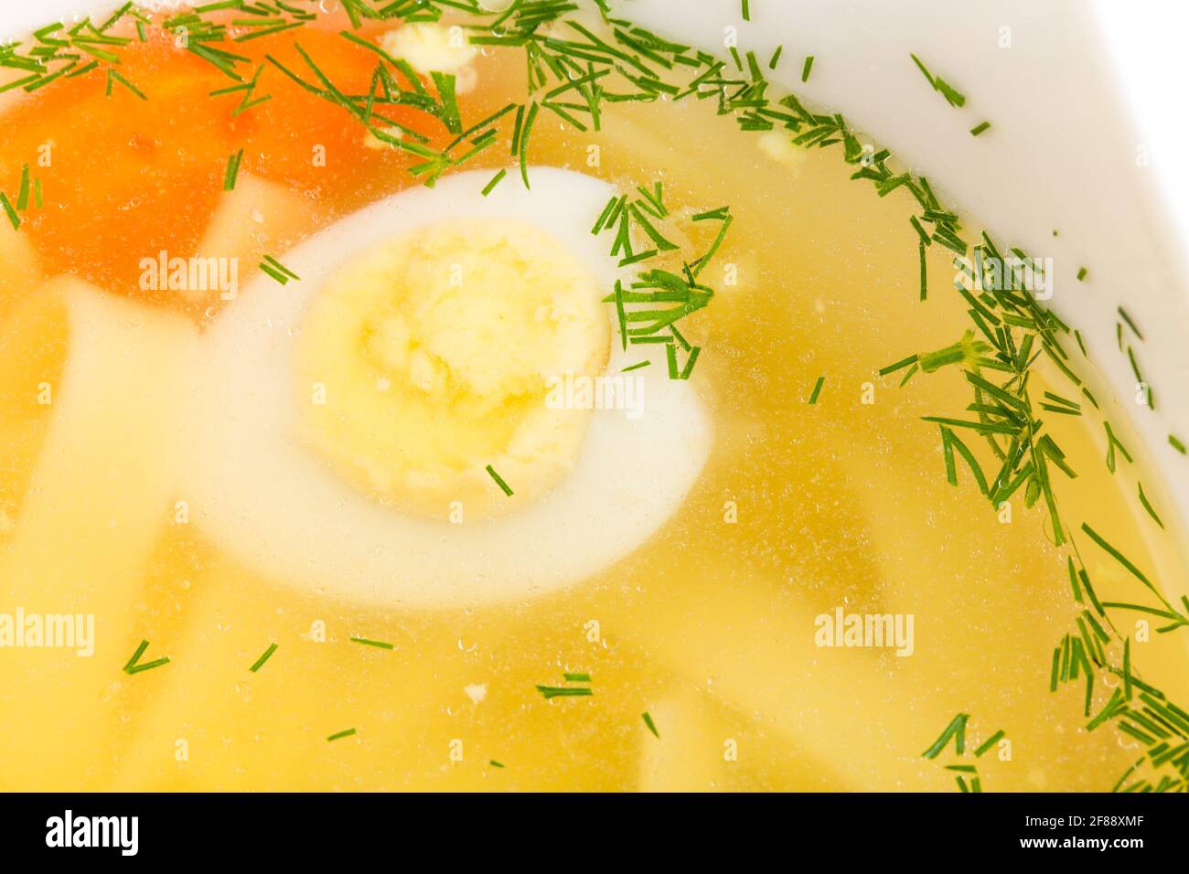 Chicken consomme soup with homemade noodles and quail eggs. Macro