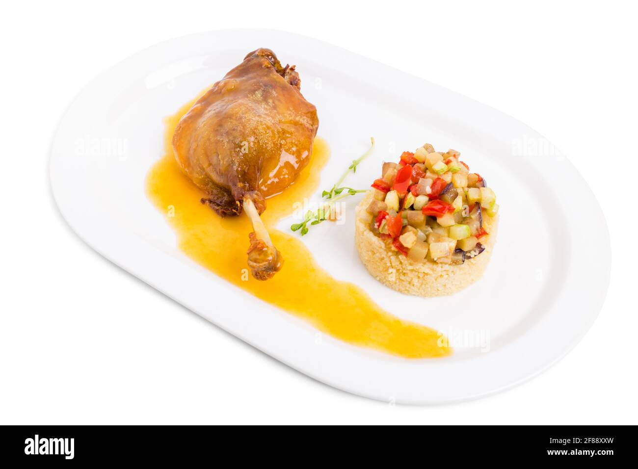 Duck leg confit with couscous and baked vegetables. Isolated on a white background. Stock Photo