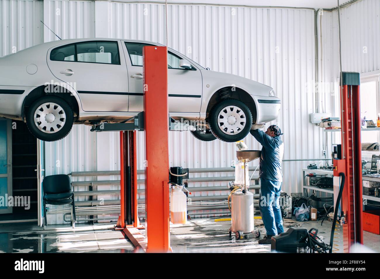 Car lifted on car lift for routine maintenance Stock Photo - Alamy