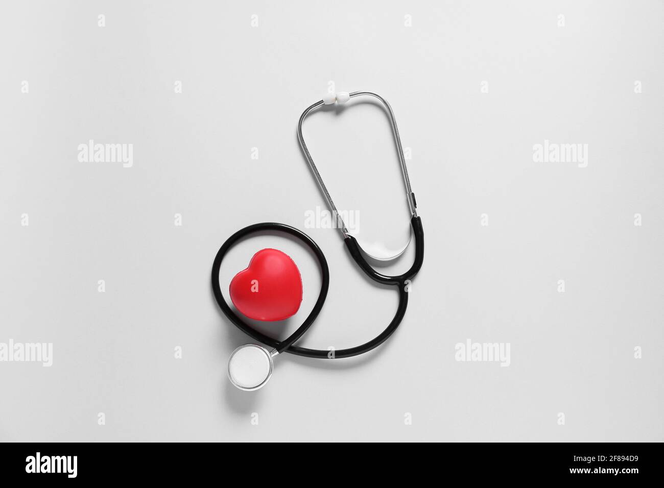 Modern stethoscope and heart on light background Stock Photo - Alamy