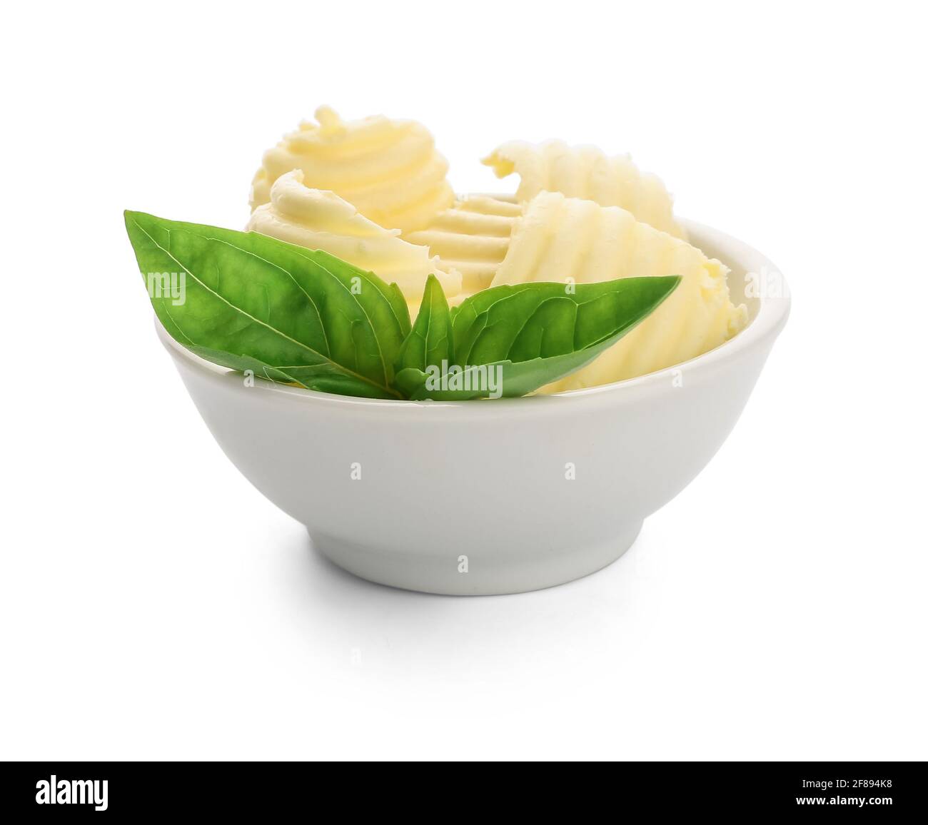Bowl with fresh butter and basil on white background Stock Photo Alamy