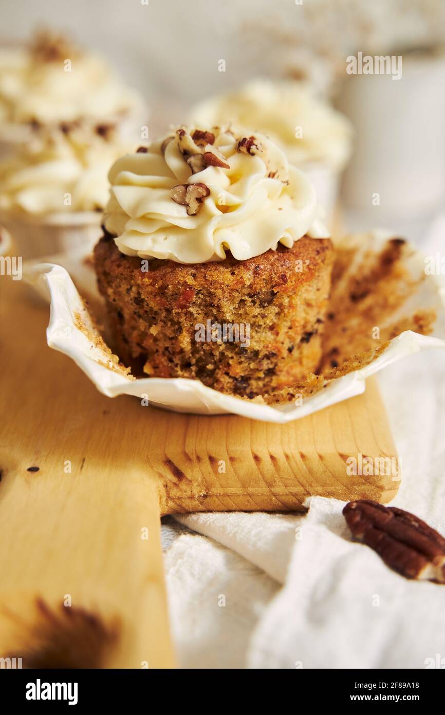 Delicious carrot cupcake with whipped cream and topping from nuts Stock Photo