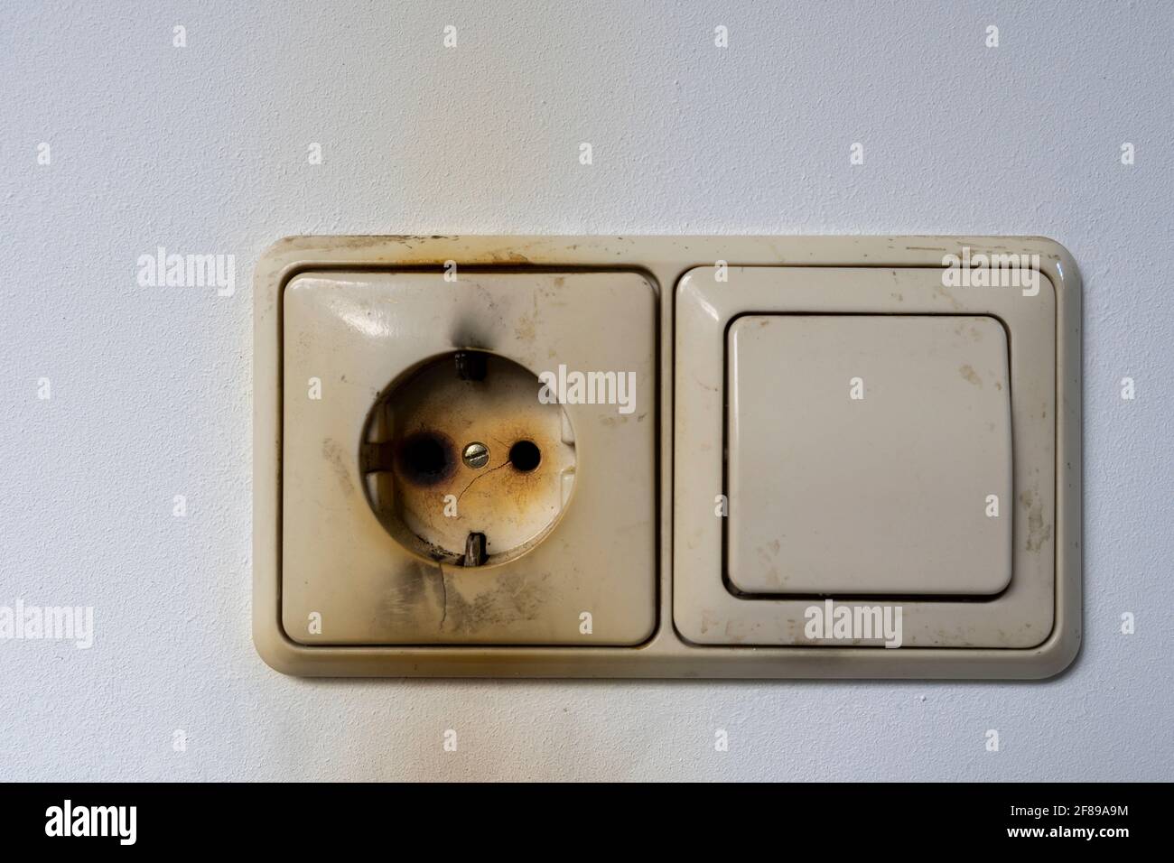 Close-up of electrical fire with the wire and wall plug Stock Photo