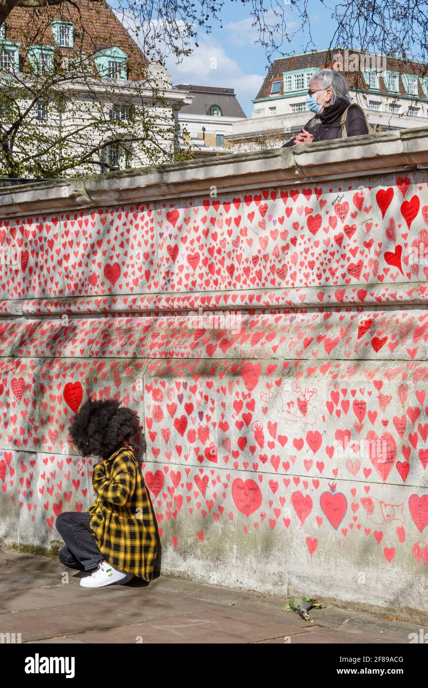 Red hearts painted on the National Covid Memorial Wall as a tribute to the British victims of the Coronavirus pandemic . Stock Photo