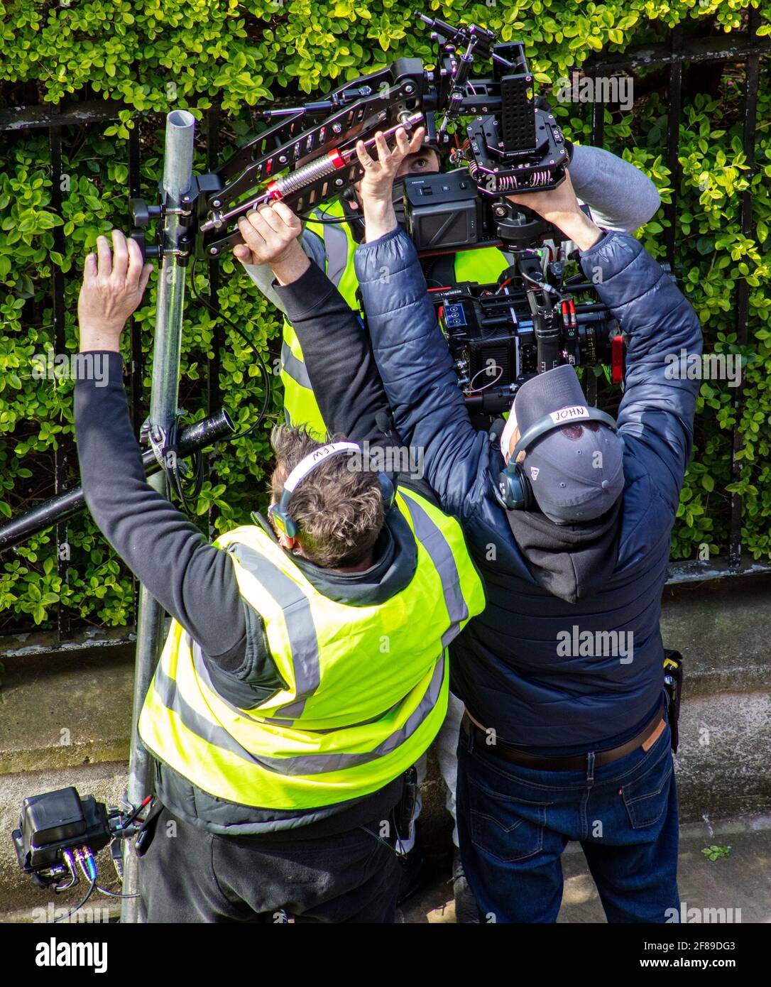 Grips (part of the crew) in hivis jackets working on a camera and