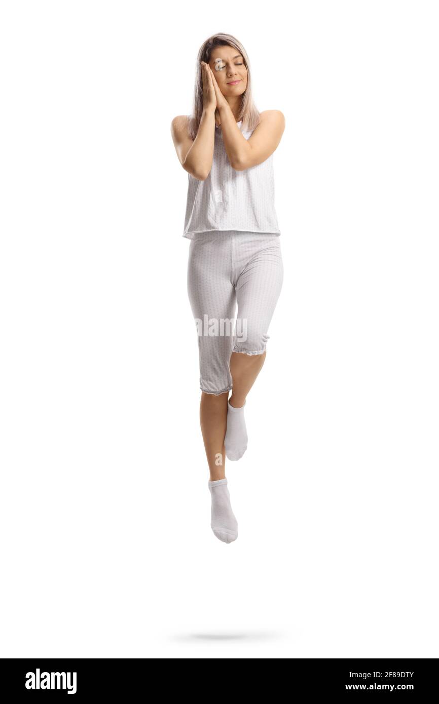 Young woman in pajamas sleeping and levitating isolated on white background Stock Photo