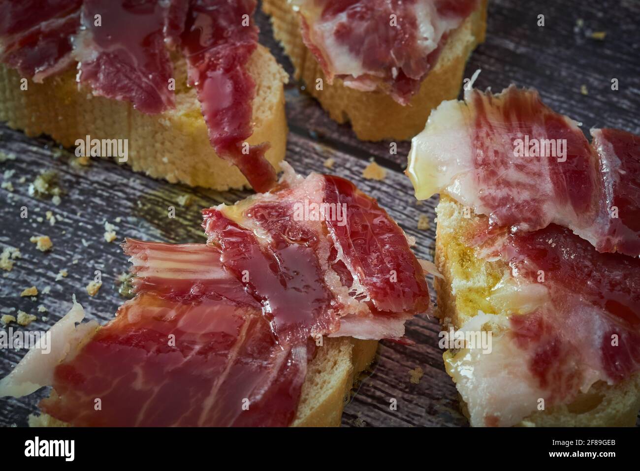 Some slices of bread with Iberian ham and olive oil Stock Photo - Alamy