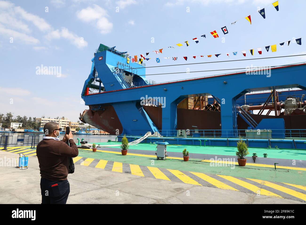 Ismailia, Egypt. 12th Apr, 2021. A man takes photos of a large cutter suction dredger (CSD) on Timsah Lake in Ismailia, Egypt, on April 12, 2021. Egypt's Suez Canal Authority (SCA) celebrated on Monday the recent arrival of the large cutter suction dredger (CSD). Credit: Ahmed Gomaa/Xinhua/Alamy Live News Stock Photo