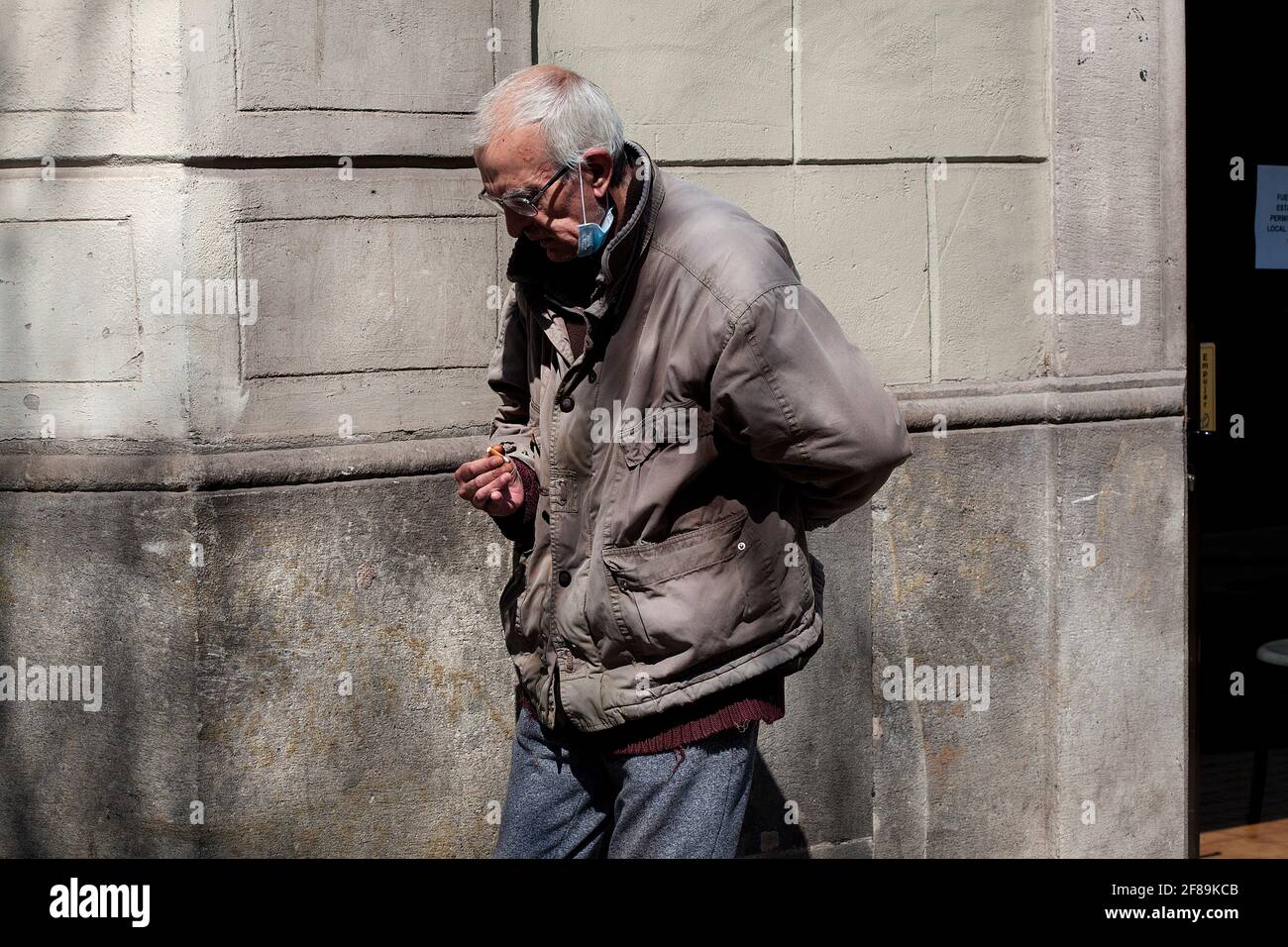 Mentally ill man smoking a cigarette in the street. Stock Photo