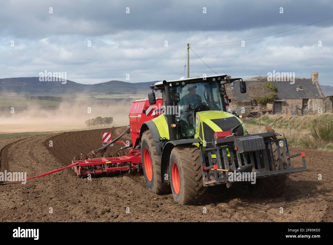 A Front View of a Tractor Pulling a Universal Seed Drill in a Field in Rural Scotland Stock Photo