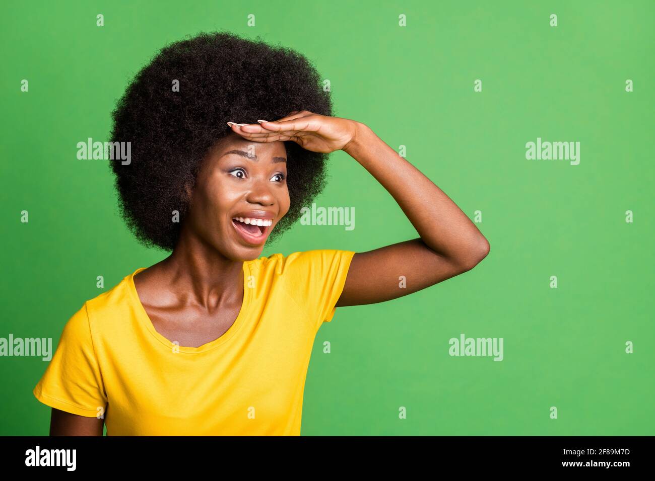 Photo of young happy excited crazy afo woman looking forward ahead in copyspace isolated on green color background Stock Photo