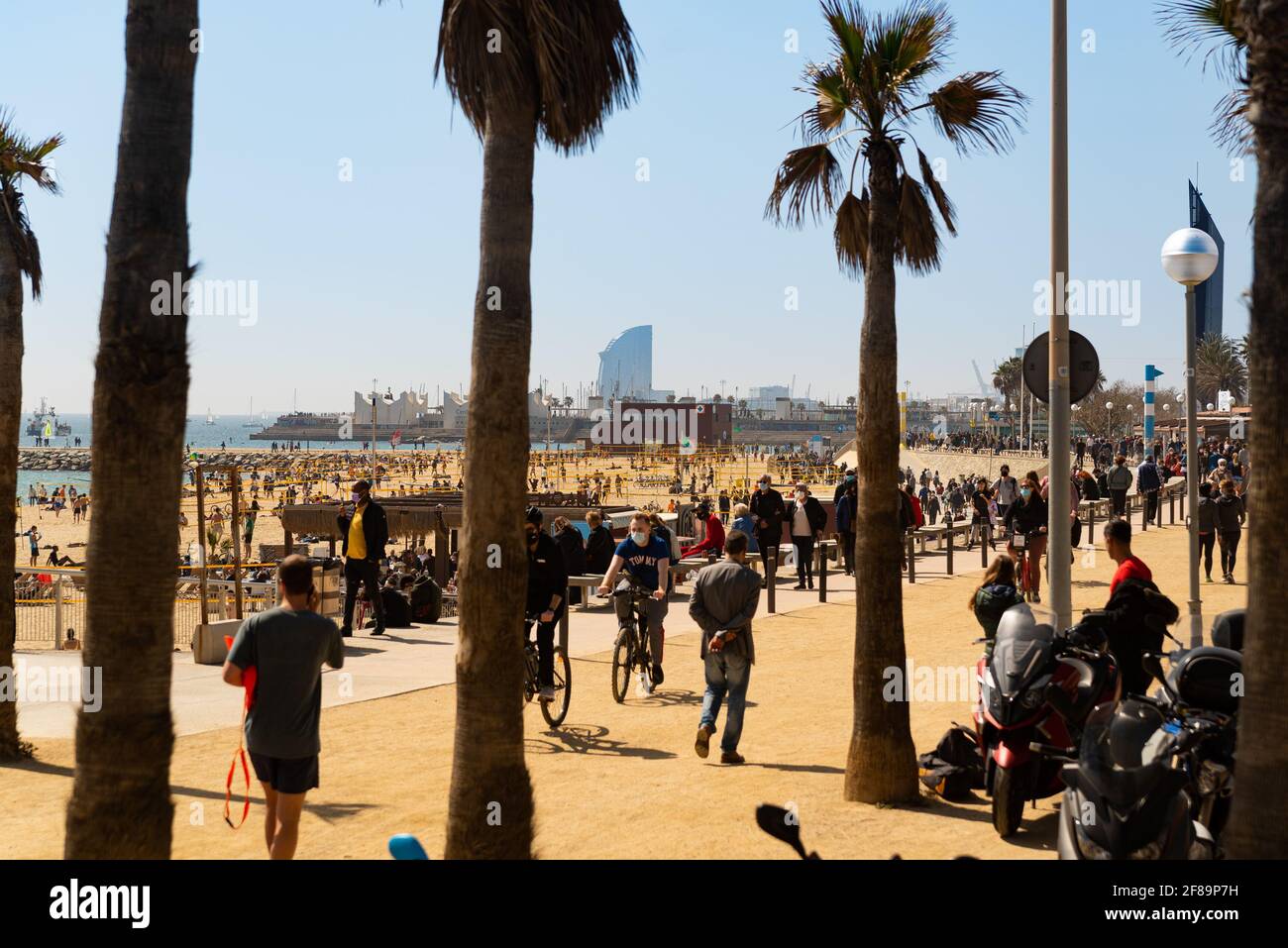 Barcelona, Spain. 06th Apr, 2021. People walk and jog in a crowded Barceloneta beach with the W hotel on the background in Barcelona, Spain on March 2021. Covid19 confinement measures are becoming more relaxed in as the government tries to push the economic recovery and the tourism industry (Photo by Davide Bonaldo/Sipa USA) Credit: Sipa USA/Alamy Live News Stock Photo