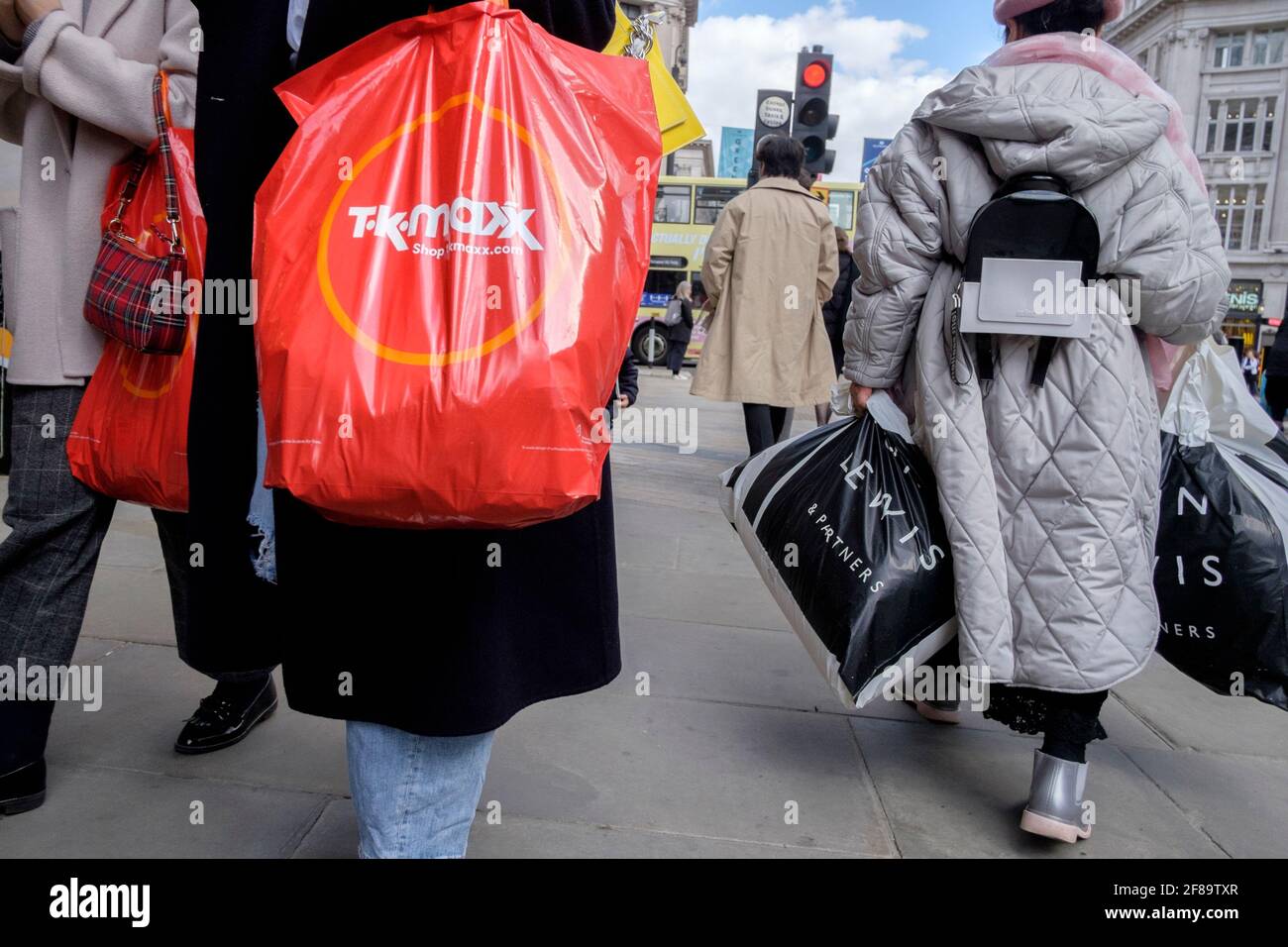 Shoppers with Louis Vuitton bags in Oxford Street London, pass bus with  advert for fashion outlet boohoo Stock Photo - Alamy