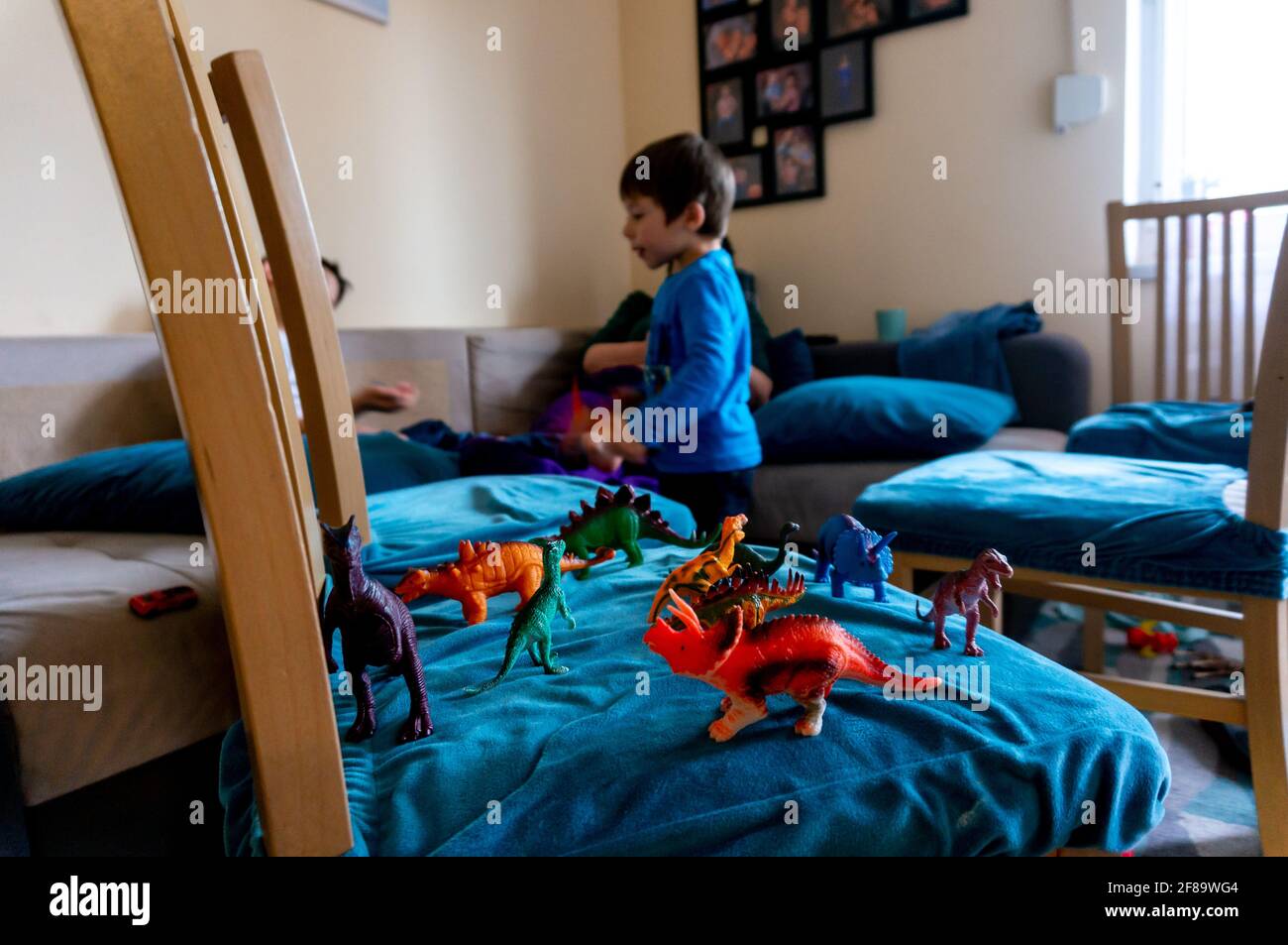 POZNAN, POLAND - Apr 10, 2021: Mix of dinosaur figurines on a chair in a living room of a Polish home. Stock Photo