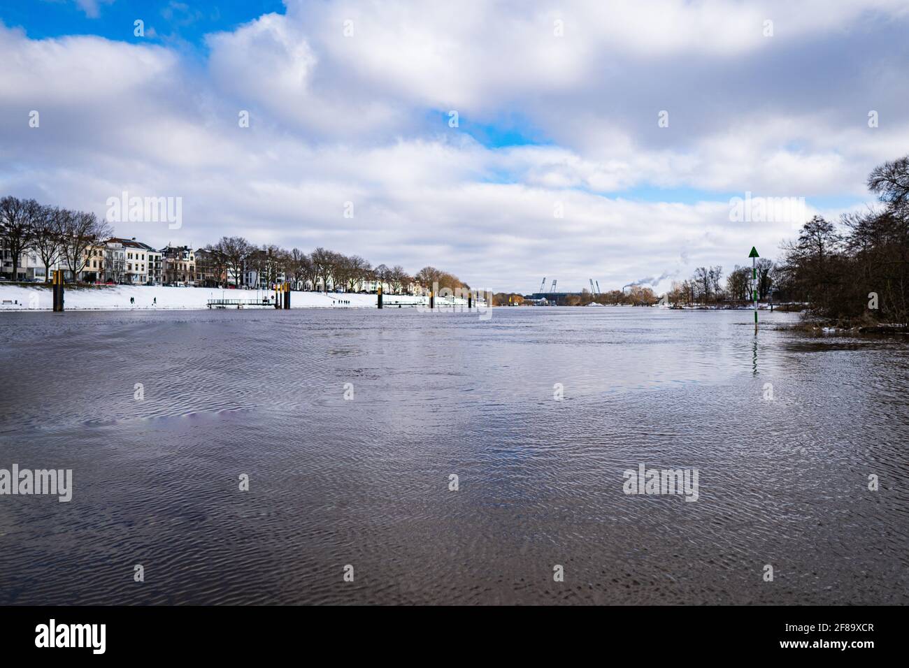 view over weser and snowy osterdeich from wooden landing stage in winter in bremen with stadium in the background Stock Photo