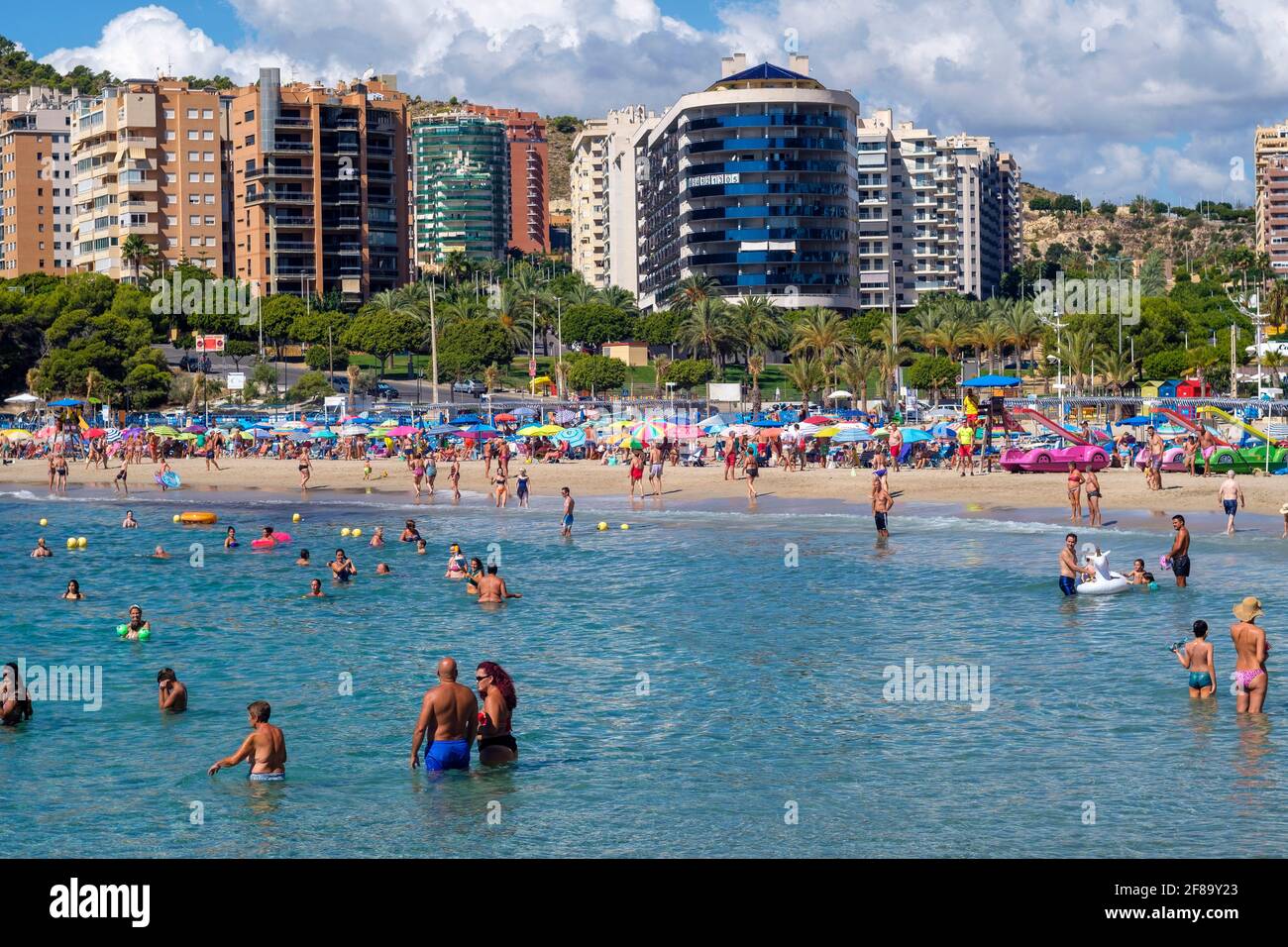 Vacationers in front of high-rise buildings in the water and on the beach of Cala Finestrat, Alicante, Spain on September 12, 2020 Stock Photo