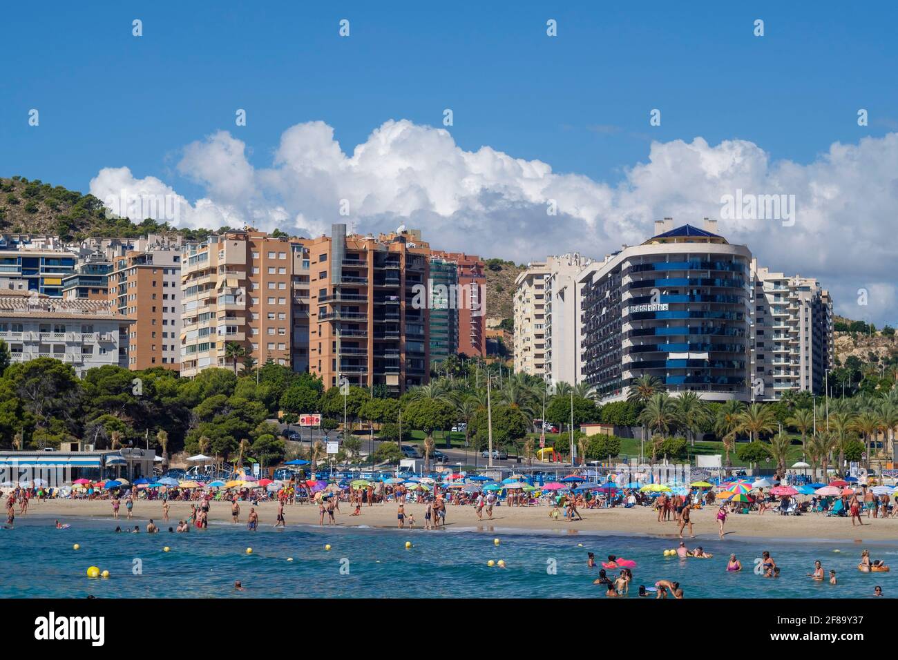 Vacationers in front of high-rise buildings in the water and on the beach of Cala Finestrat, Alicante, Spain on September 12, 2020 Stock Photo