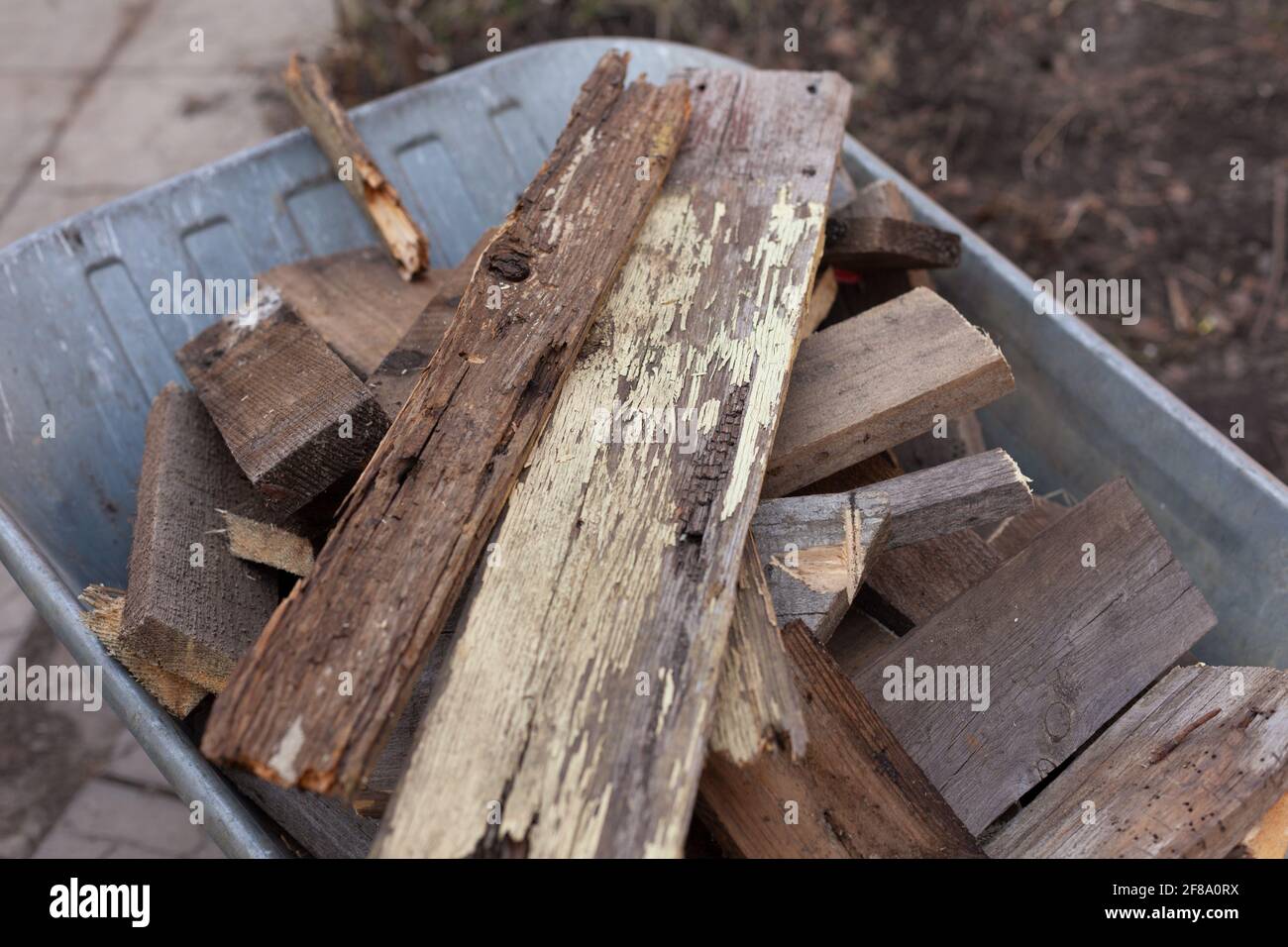Old wooden planks laying in a wheelbarrow. Close up. Stock Photo